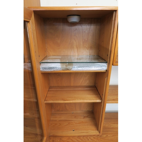 67 - A 20th century elm and beech Ercol sideboard with pair of glazed cabinets flanking central open shel... 