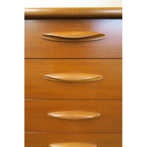 69 - A mid 20th century teak tall boy six drawer chest with shaped drawer pulls on plinth base, 115cm hig... 