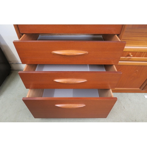 69 - A mid 20th century teak tall boy six drawer chest with shaped drawer pulls on plinth base, 115cm hig... 