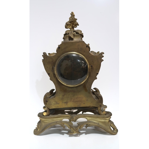 243 - A French gilt metal clock of rococo style, the dial with white and blue enamel roman numeral plaques... 