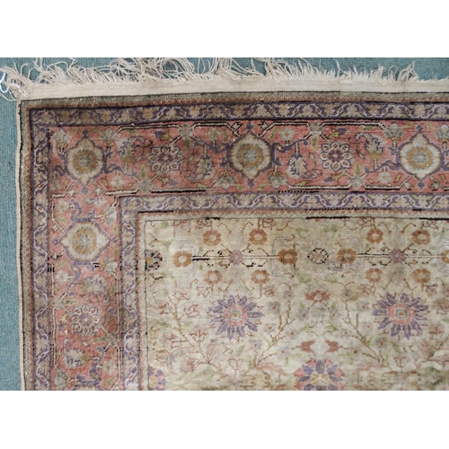 133 - A CREAM GROUND SILK AND WOOL PERSIAN RUGwith floral foliate all-over design and pink borders, 185cm ... 