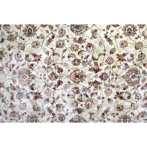 135 - A cream ground machine made Kashmiri rug with all-over floral design and flower head borders, 300cm ... 