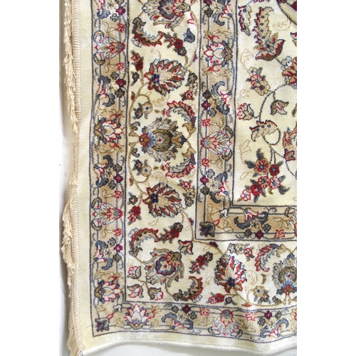 135 - A cream ground machine made Kashmiri rug with all-over floral design and flower head borders, 300cm ... 