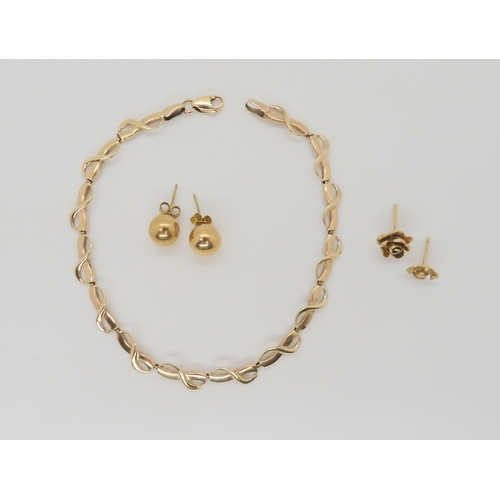 731 - A 9ct gold infinity symbol bracelet, and four gold and yellow metal earrings, weight all together 6.... 