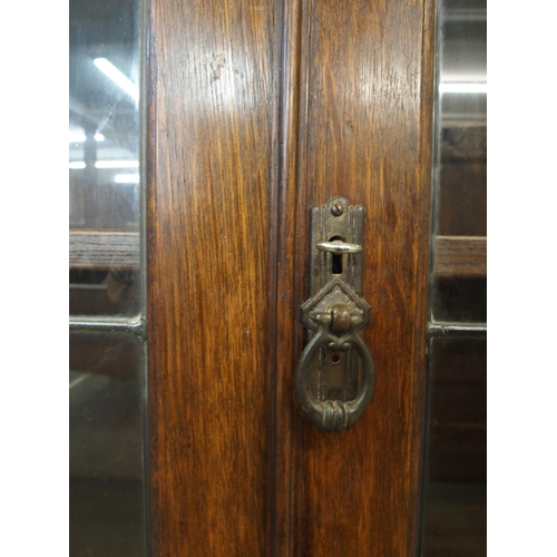 104 - A 20th century oak glazed bookcase with pair of leaded glass doors on cabriole supports, 128cm high ... 