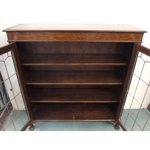 104 - A 20th century oak glazed bookcase with pair of leaded glass doors on cabriole supports, 128cm high ... 