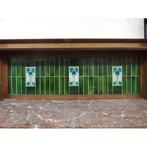 114 - A late Victorian oak arts and crafts washstand with green tiled splashback over marble top above pai... 