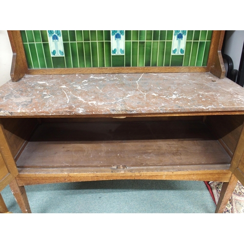 114 - A late Victorian oak arts and crafts washstand with green tiled splashback over marble top above pai... 