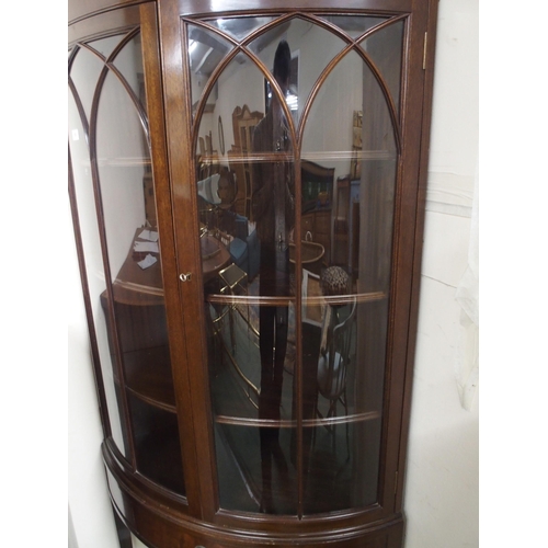 126 - A 20th century mahogany bow front glazed corner cabinet with pair of glazed doors over single drawer... 