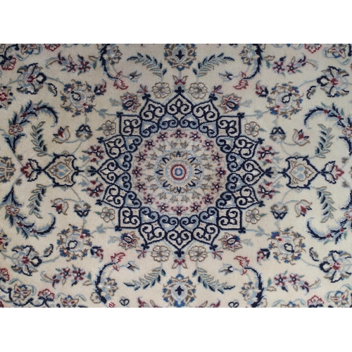 129 - A cream ground Nain rug with multicoloured sunburst central medallion, floral patterned ground and f... 