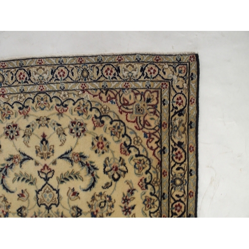 129 - A cream ground Nain rug with multicoloured sunburst central medallion, floral patterned ground and f... 