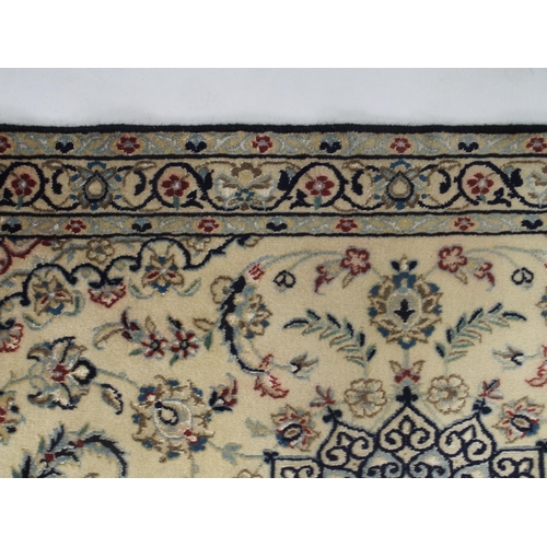 129 - A cream ground Nain rug with multicoloured sunburst central medallion, floral patterned ground and f... 