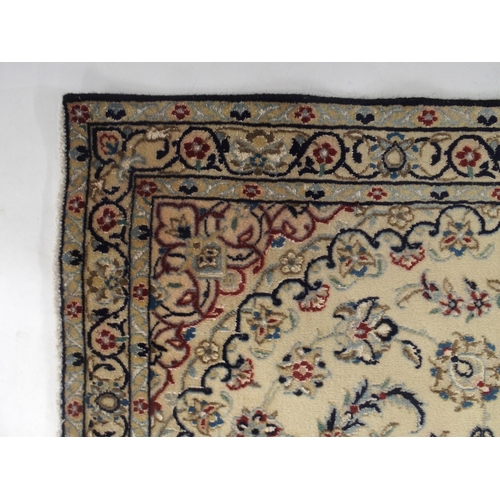 129 - A cream ground Nain rug with multicoloured sunburst central medallion, floral patterned ground and f... 