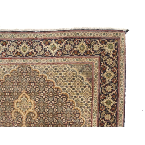 150 - A multicoloured ground Tabriz rug with green central medallion, matching spandrels and a dark blue f... 