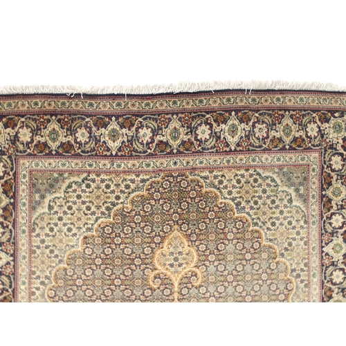 150 - A multicoloured ground Tabriz rug with green central medallion, matching spandrels and a dark blue f... 