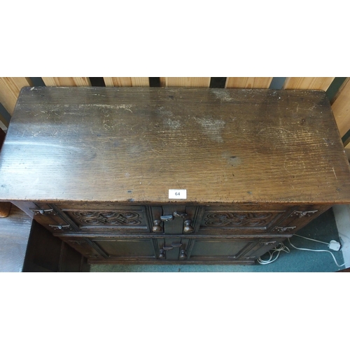 64 - A 20th century oak side cabinet with pair of carved cabinet doors over pair of panel doors on block ... 