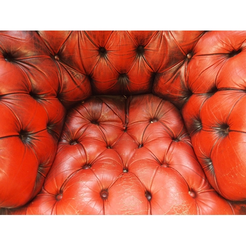 75 - A 20th century red leather button back upholstered Chesterfield style club armchair, 69cm high x 114... 