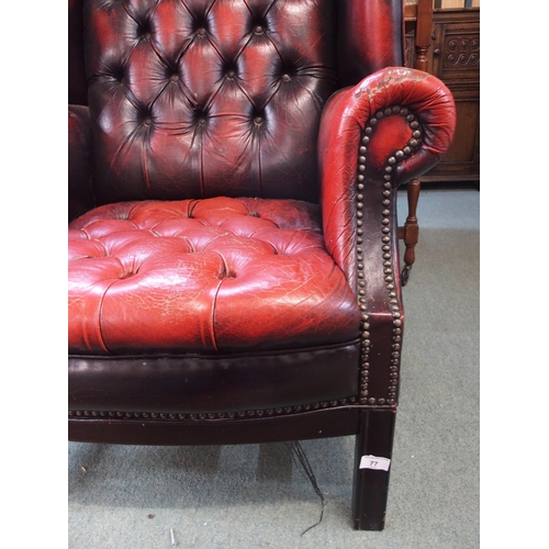 77 - A 20th century red leather button back upholstered Chesterfield style wing back armchair, 109cm high... 