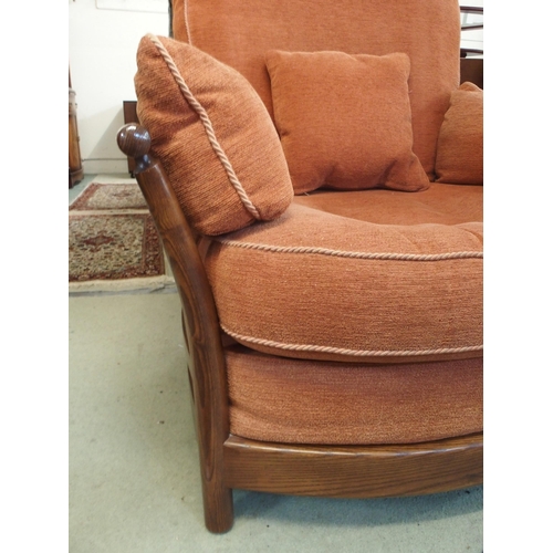 79 - A 20th century elm and beech framed Ercol golden dawn armchair with terracotta upholstery, 96cm high... 