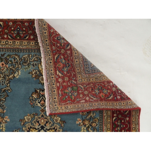 91 - A light blue ground Qom rug with dark blue floral medallion, matching spandrels and red flower head ... 