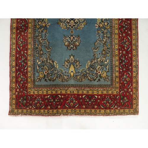 91 - A light blue ground Qom rug with dark blue floral medallion, matching spandrels and red flower head ... 