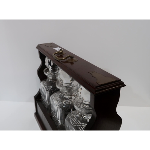 247 - A Three cut glass decanter tantalus, with three silver spirit labels