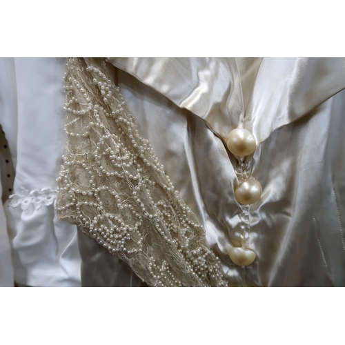 267 - An early 20th century satin wedding dress with beaded lace arms, together with a later wedding dress