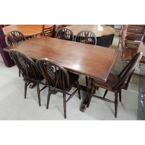 89 - A 20th century stained elm refectory dining table, 75cm high x 152cm long x 76cm deep and six wheel ... 