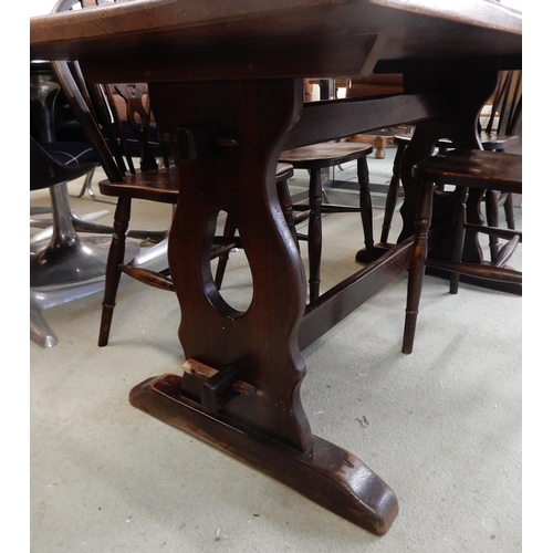 89 - A 20th century stained elm refectory dining table, 75cm high x 152cm long x 76cm deep and six wheel ... 