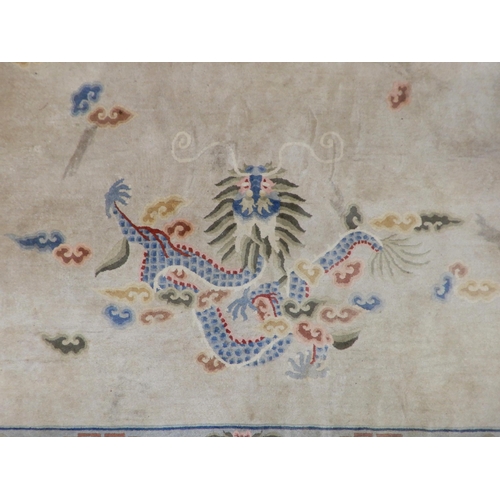 92 - A cream ground Oriental style rug with dragon design on ground surrounded by blue floral borders, 37... 