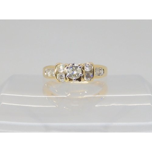 692 - A 14k gold diamond ring, the central high prong set diamond is estimated approximately at 0.20cts wi... 