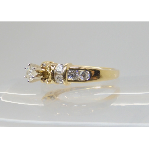 692 - A 14k gold diamond ring, the central high prong set diamond is estimated approximately at 0.20cts wi... 