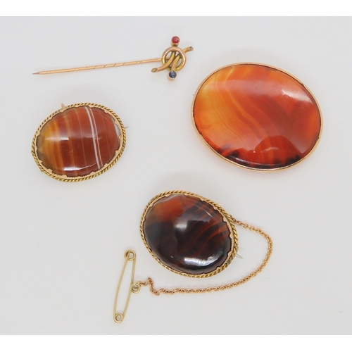 703 - Three yellow metal mounted agate specimen brooches, together with a 9ct gold red and blue gem set pi... 