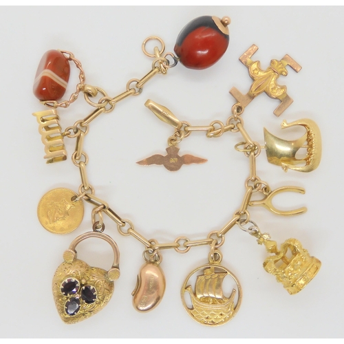 704 - A 9ct gold charm bracelet with five 9ct hallmarked charms to include a Scouting swastika charm, a Jo... 