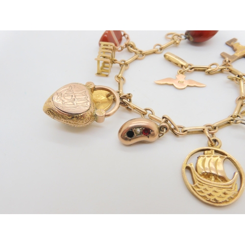 704 - A 9ct gold charm bracelet with five 9ct hallmarked charms to include a Scouting swastika charm, a Jo... 