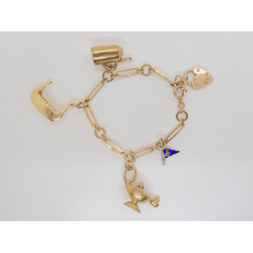 710 - A 9ct gold charm bracelet with three 9ct charms to include a Genie's lamp, a 14k Viking longship (ap... 