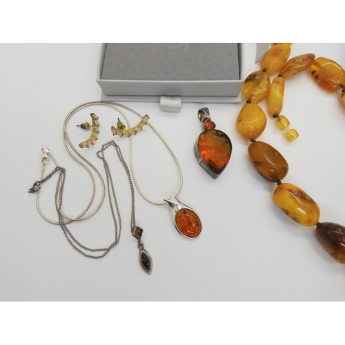 760 - A string of amber coloured beads, further silver items set with amber, A designer silver 'Spinner' p... 