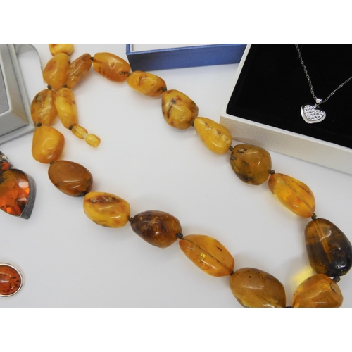 760 - A string of amber coloured beads, further silver items set with amber, A designer silver 'Spinner' p... 