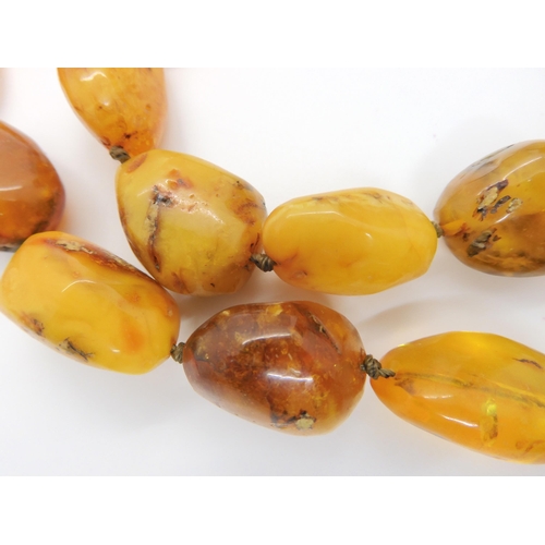 760 - A string of amber coloured beads, further silver items set with amber, A designer silver 'Spinner' p... 