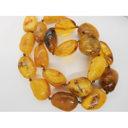 760 - A string of amber coloured beads, further silver items set with amber, A designer silver 'Spinner' p... 