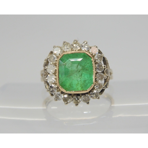 2706 - AN EMERALD AND DIAMOND RINGset throughout in yellow and white metal with diamond set fleur de lys sh... 