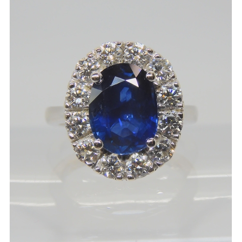 2741 - A SAPPHIRE AND DIAMOND CLUSTER RINGset throughout in 18ct white gold, set with an oval mixed cut sap... 