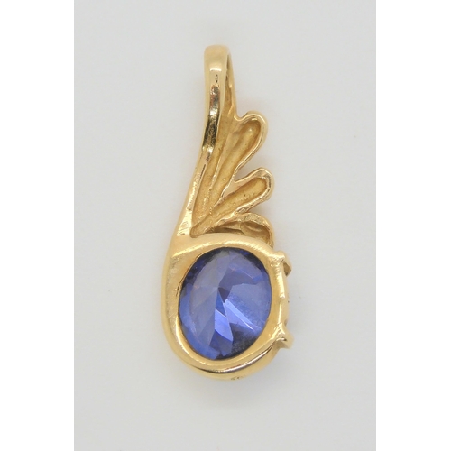 513 - A tanzanite pendant in bright yellow metal, length 2.5cm, weight 2.4gms