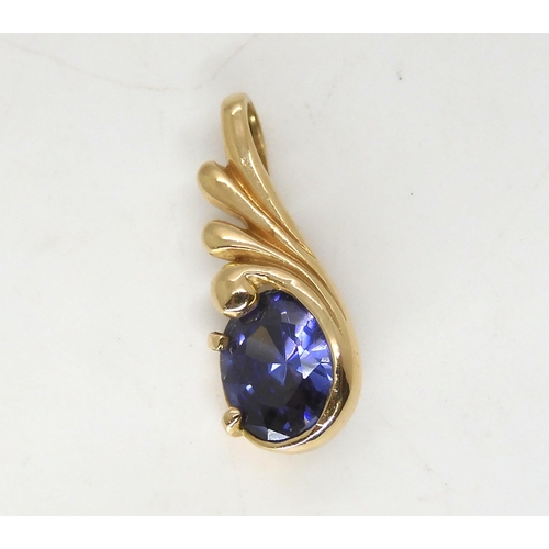 513 - A tanzanite pendant in bright yellow metal, length 2.5cm, weight 2.4gms