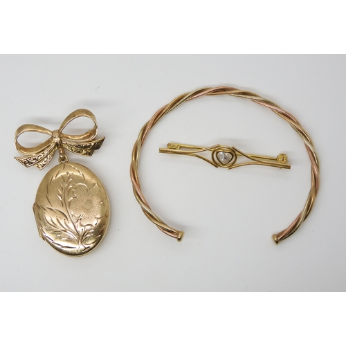 546 - A 9ct gold locket brooch with bow mount, a 9ct gold bangle and a brooch, weight together 15gms