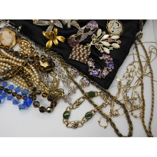 596 - A large collection of vintage brooches, beads, necklaces etc