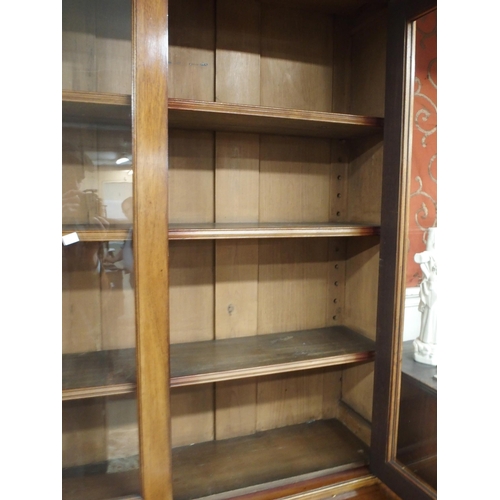 56 - A Victorian mahogany bookcase on base with moulded cornice over pair of glazed doors over drawers ov... 