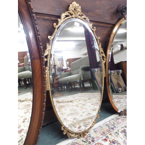 86 - A Victorian mahogany framed oval wall mirror, 59cm high x 94cm wide, a copped framed bevelled glass ... 