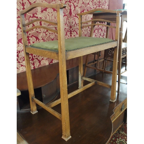 92 - An early 20th century oak arts and crafts piano stool with green upholstered seat on stretchered squ... 