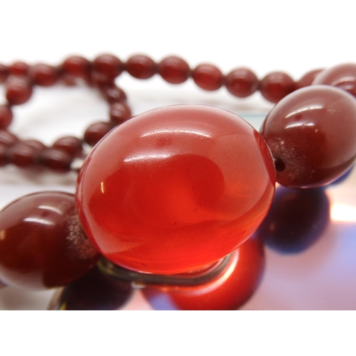 596 - A string of cherry amber coloured beads